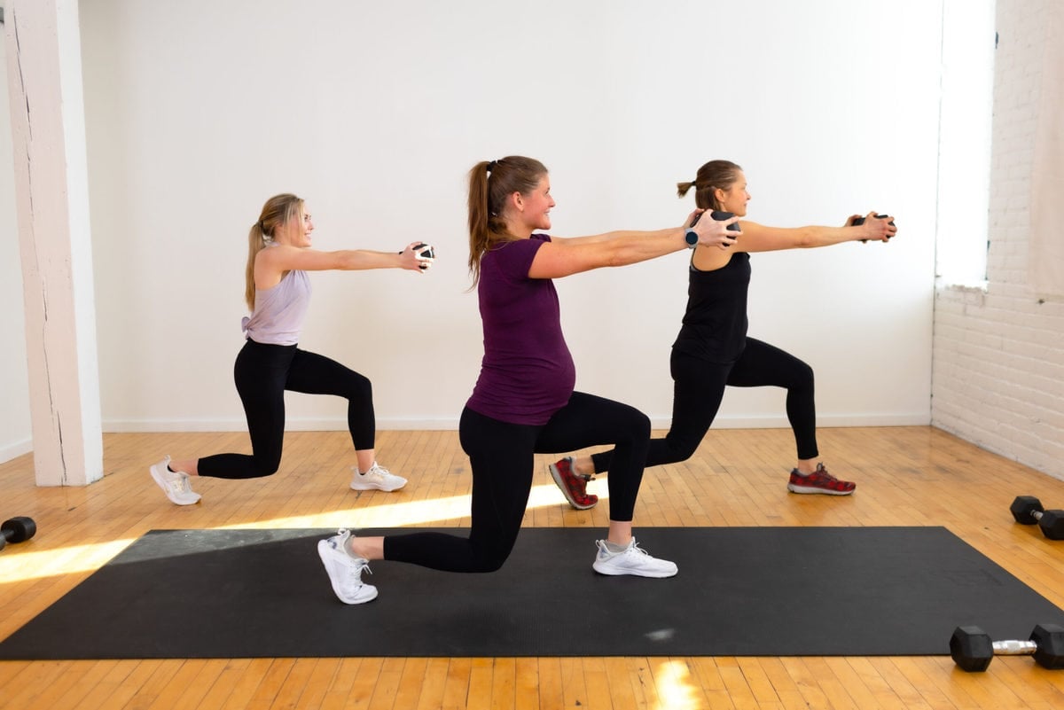 three women performing a lunge hold dumbbell press out (35 Minute HIIT Circuit Workout At Home)