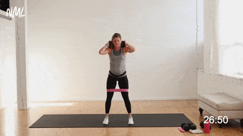 woman performing good morning exercise holding one weight on her upper back and shoulders 