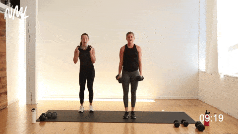 two women performing a lateral lunge with dumbbells 