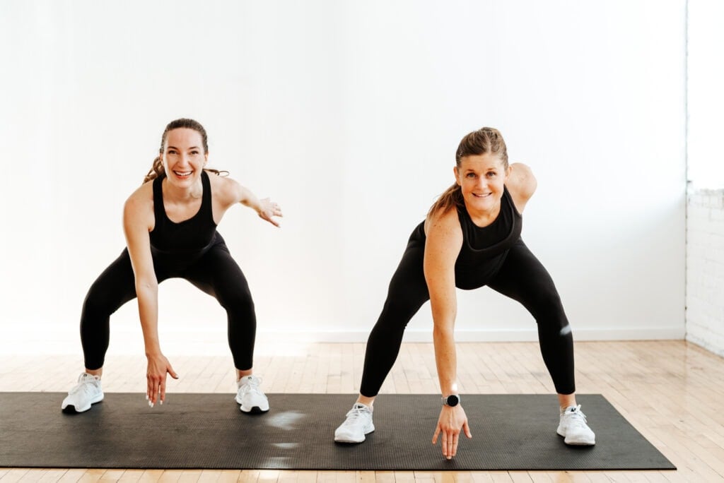 two women performing air squats in a low impact cardio workout for beginners