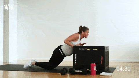 pregnant woman performing kneeling pushup on a bench, prenatal arm workout
