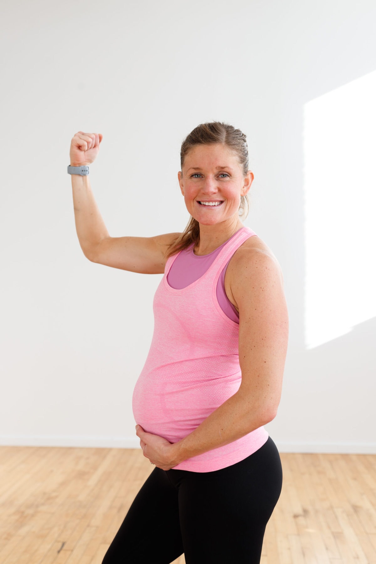 strong pregnant woman flexing arm muscles