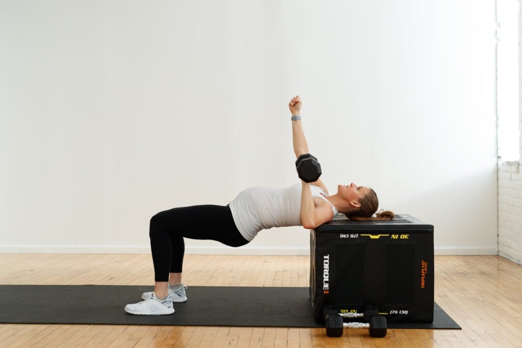 Pregnant woman performing a dumbbell chest press on an incline bench | chest exercises for pregnancy