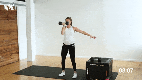woman performing a standing, single arm Arnold press 