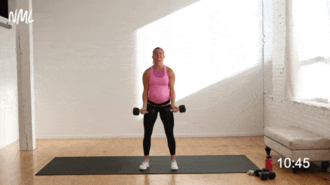 pregnant woman performing a standard bicep curl with dumbbells in a pregnancy arm workout