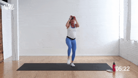 pregnant woman performing a front knee drive and rear kick, prenatal bodyweight workout