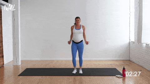 pregnant woman performing side-to-side squat, prenatal bodyweight workout at home