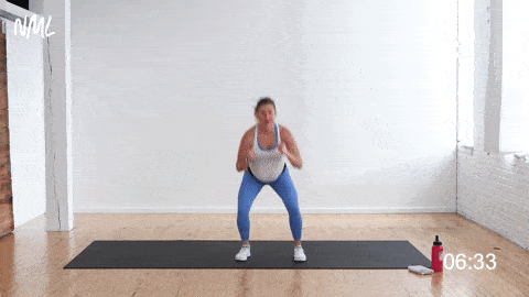 pregnant woman performing bodyweight cardio exercise, squat and punch