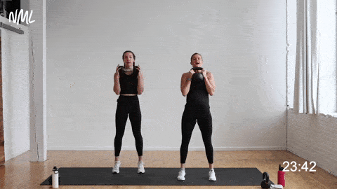 two women performing a kettlebell deadlift and clean with a calf raise