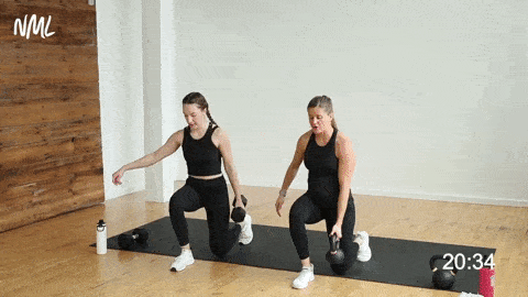 two women performing kettlebell lunges 