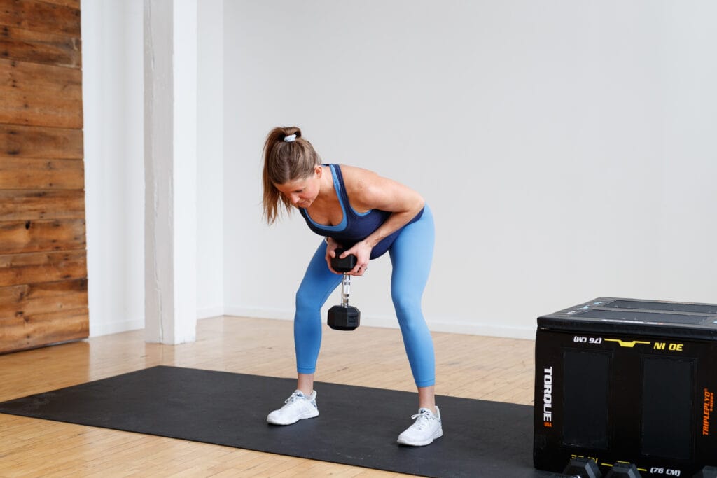 pregnant woman performing bent over back row with one dumbbell, back exercises for pregnancy