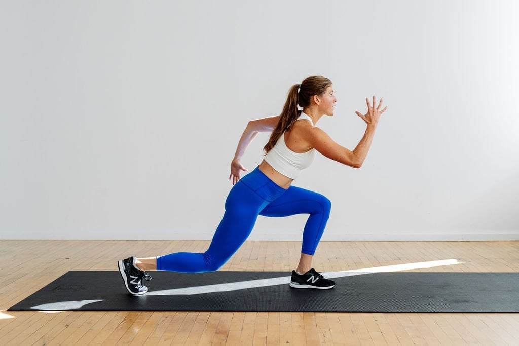 A bodyweight full body strength workout with no equipment. Woman performing a bodyweight reverse lunge.