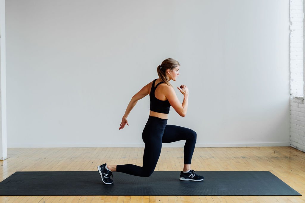 woman performing a forward lunge as part of a HIIT leg workout