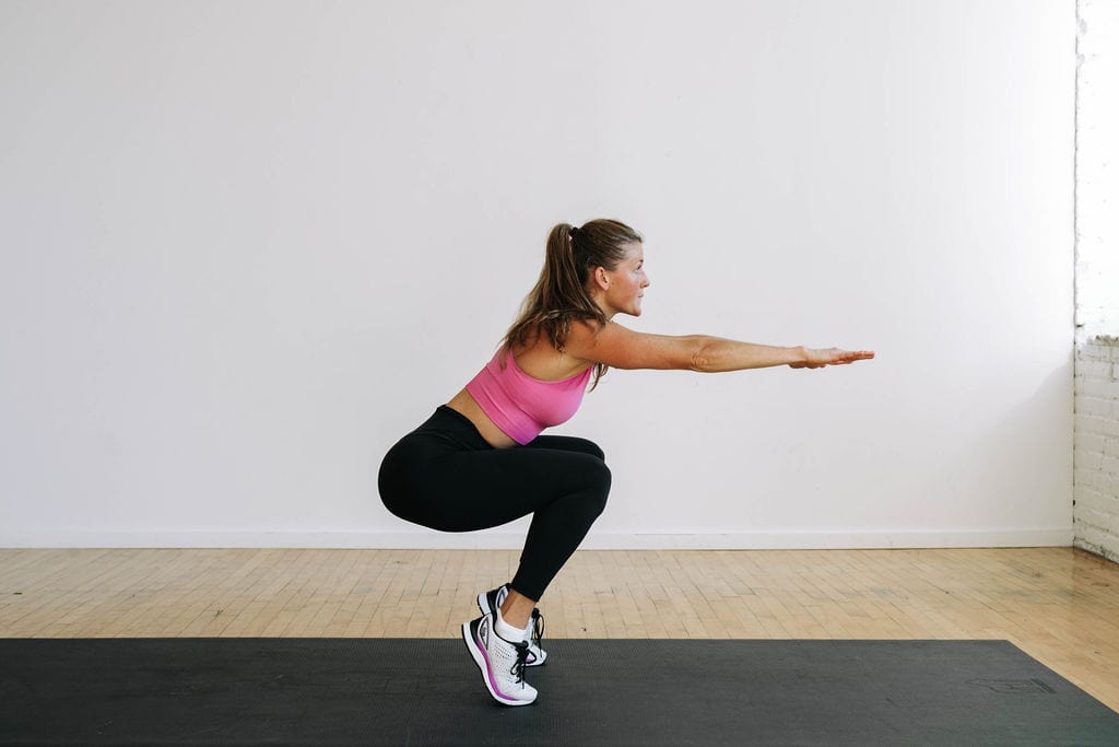woman performing a squat on toes