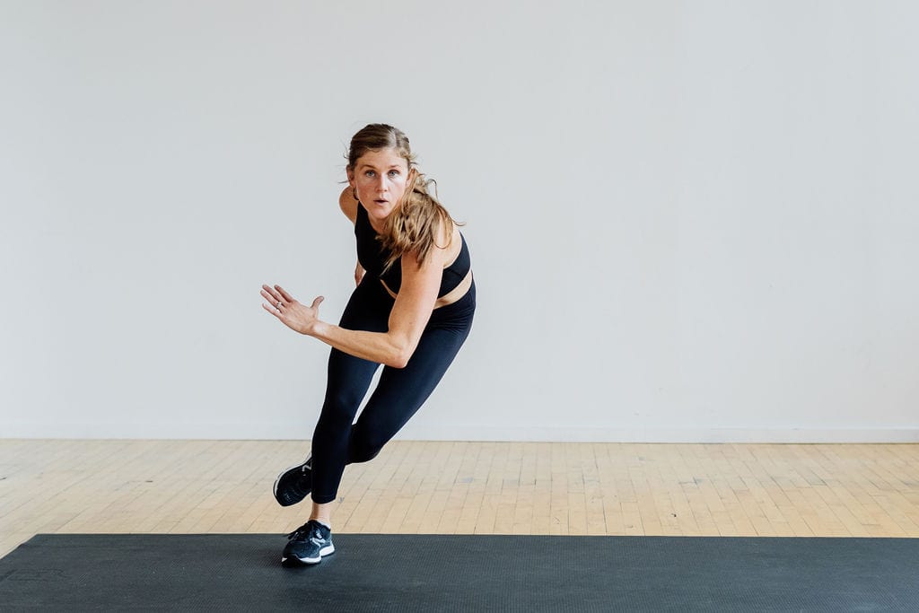 Woman performing a lateral bound in this HIIT leg workout, no equipment.