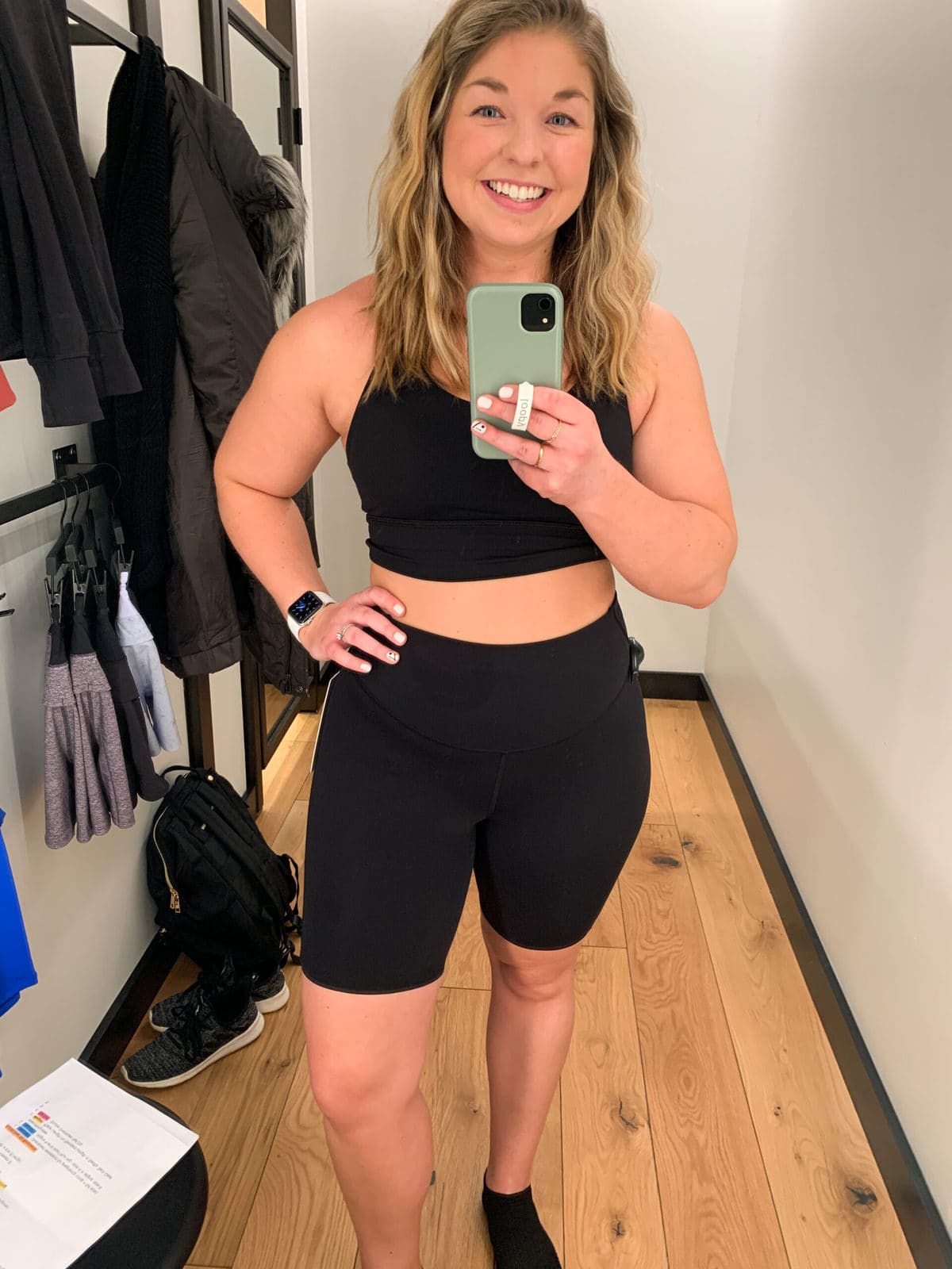 woman wearing black biker shorts for running in front of mirror