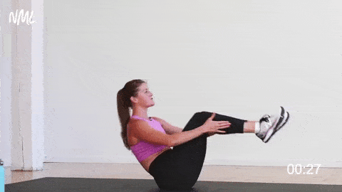 woman performing a boat pose hold and heel reach as part of a no equipment workout