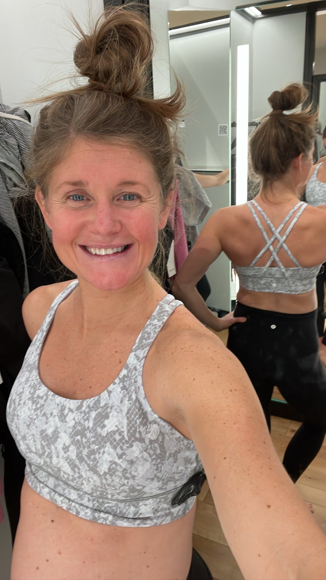Woman taking picture of herself wearing Energy bra from front and back