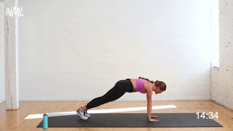 woman performing a crossbody to center knee drive from a high plank position