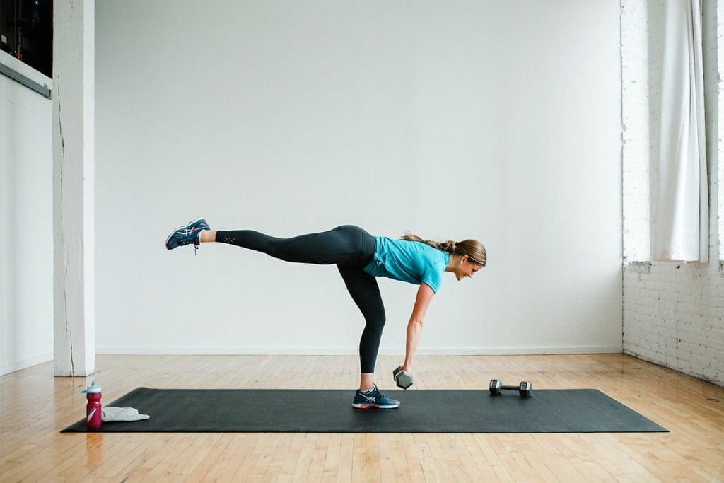 Woman performing a Single Leg Deadlift exercise with dumbbell. During a full body hiit workout. 