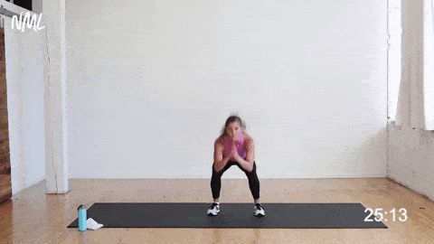 woman performing squat jumps as part of no equipment workout