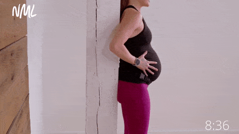 pregnant woman demonstrating transverse abdominis or TA breathing or belly breathing during pregnancy