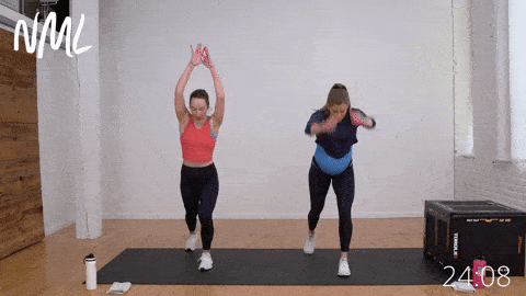 two women performing alternating knee drives as part of prenatal cardio workout