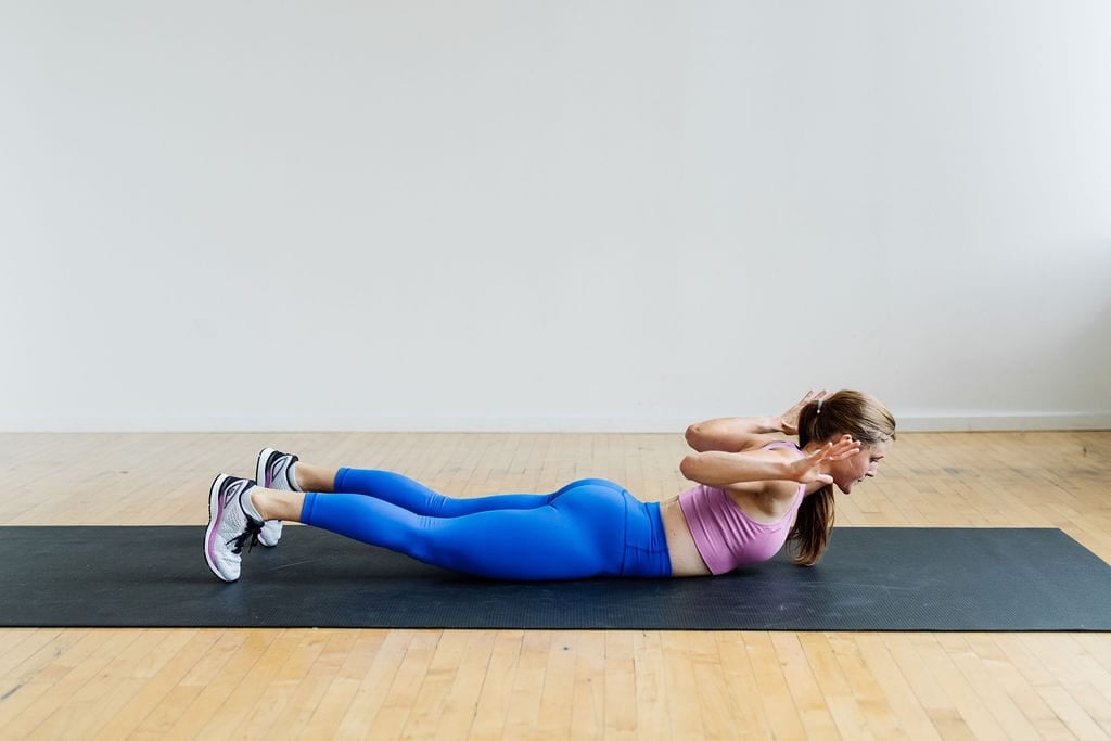 woman performing superman extension as part of bodyweight arm workout