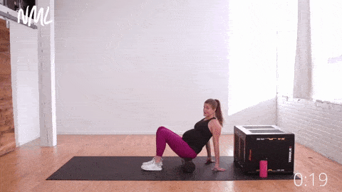 pregnant woman performing Foam Roller Glute and Piriformis Stretch