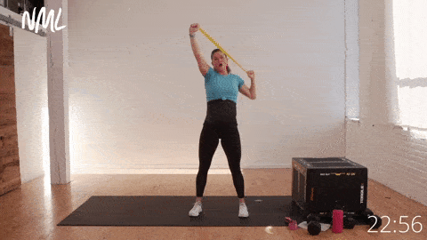 pregnant woman performing lat pull downs with mini loop resistance band