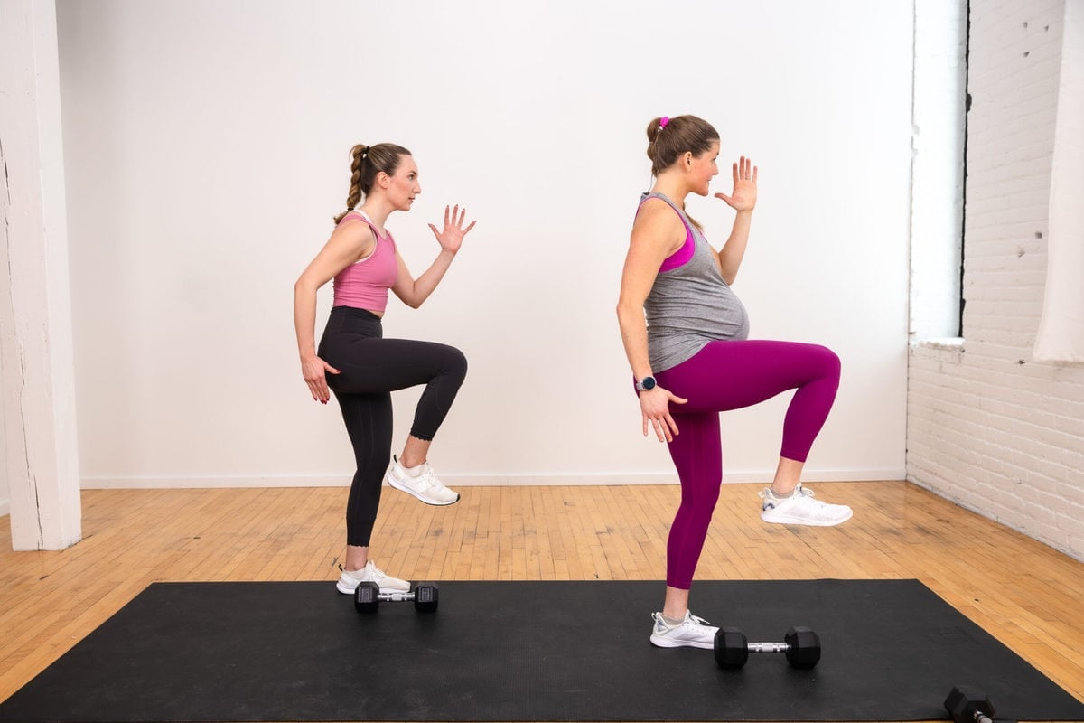 two women, one pregnant, performing a knee drive