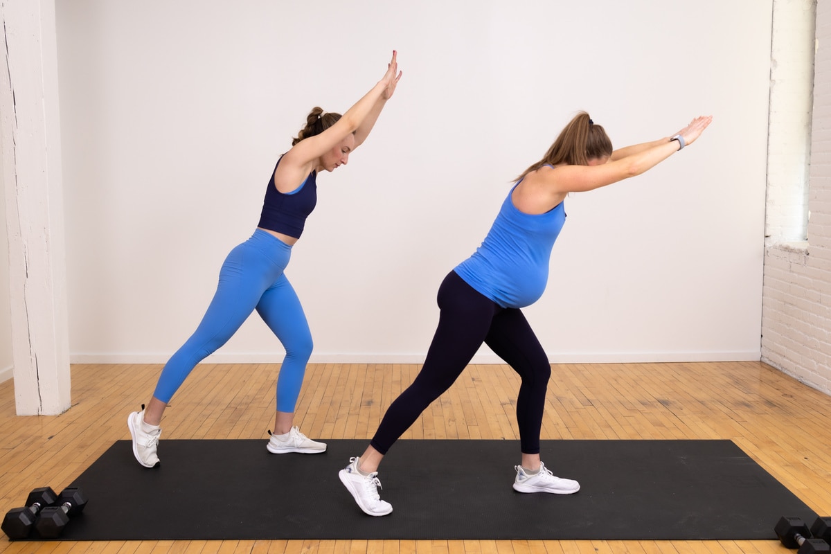 two women (one pregnant woman) performing a low lunge knee drive as part of an advanced pregnancy workout at home