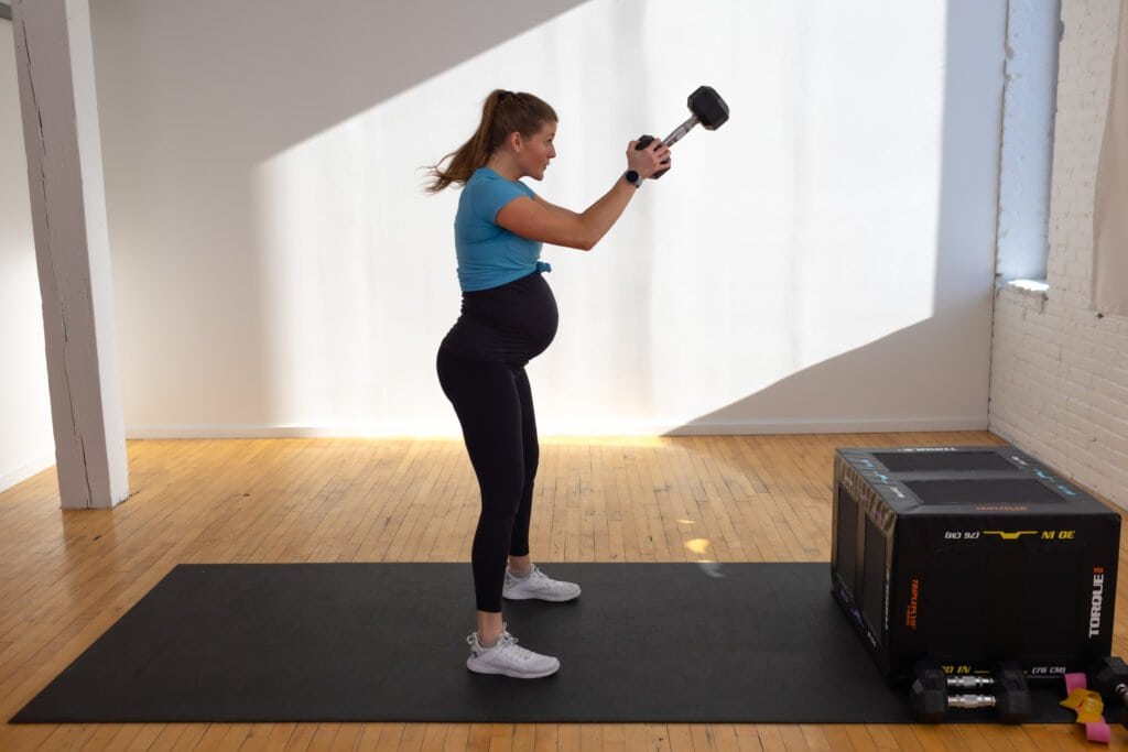 pregnant woman performing dumbbell swing exercise