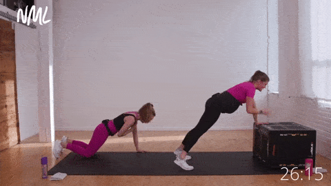 two women performing incline push up and shoulder taps. The woman on the right takes her push ups from a bench to make this a pregnancy safe exercise. 