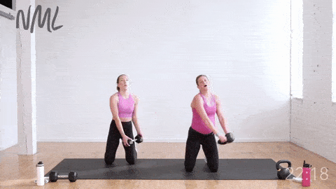 two women performing a kneeling rainbow exercise with kettlebells to strengthen the shoulder and core muscles