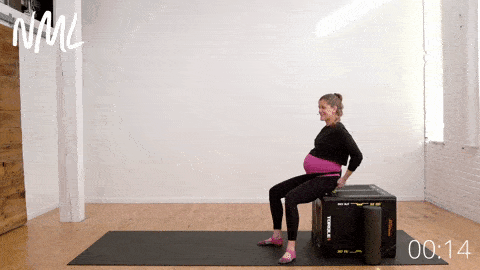 woman performing a seated piriformis release with ball, sciatica stretches