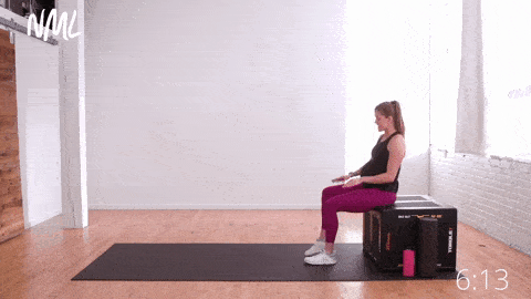 pregnant woman performing a seated piriformis stretch or seated half pigeon stretch