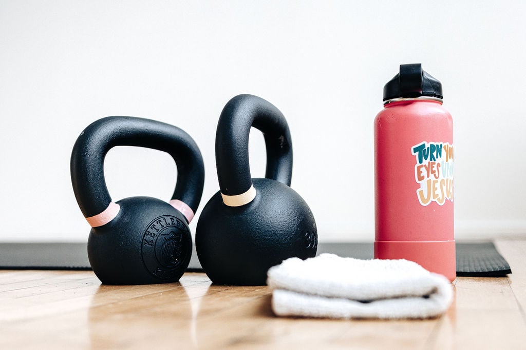 two kettlebells, a sweat towel and a water bottle