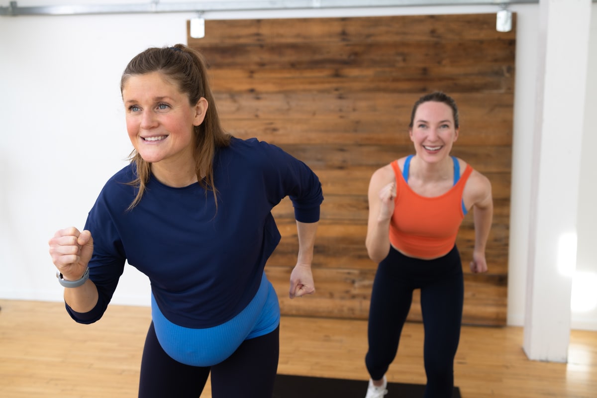 two women performing knee drives in a low impact prenatal cardio workout