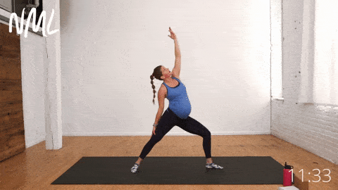 pregnant woman performing warrior two pose to reverse warrior pose in prenatal yoga routine