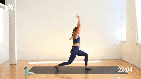 woman performing crescent lunge and arm sweeps as part of intense yoga workout