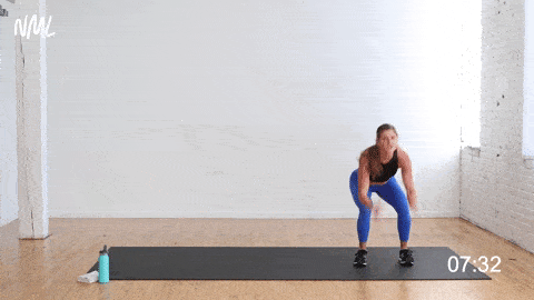 woman performing a lateral shuffle and squat jump as part of bodyweight hiit workout
