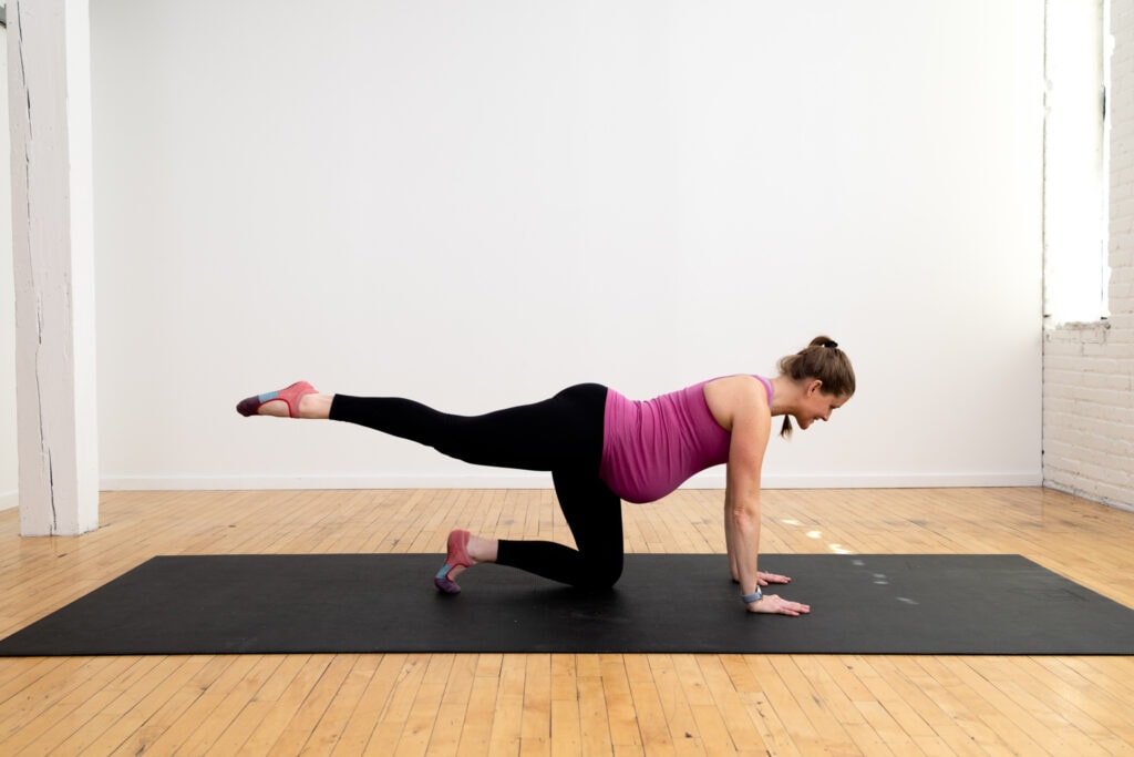 pregnant woman performing a rear leg extension