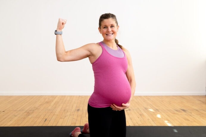 pregnant woman performing a bicep flex | pregnancy pilates workout