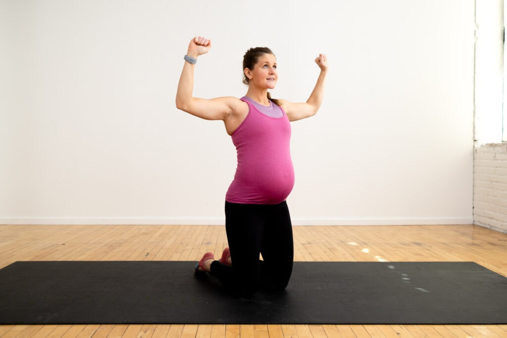 pregnant woman performing thigh dancing with goal post arms as part of prenatal pilates workout