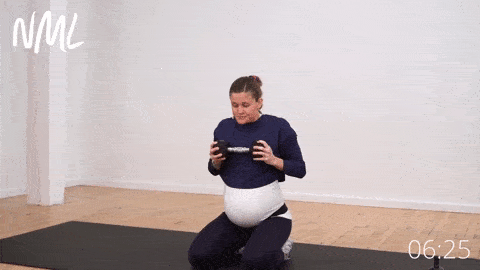 pregnant woman performing a kneeling hip lift with dumbbell press out to strengthen the core during pregnancy
