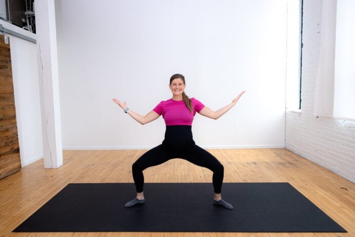 pregnant woman performing a second position arm toning series as part of pregnancy barre workout