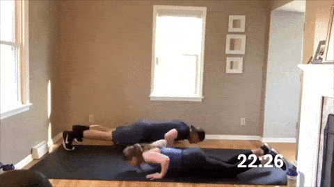 man and woman performing plyometric push ups in a HIIT cardio workout at home
