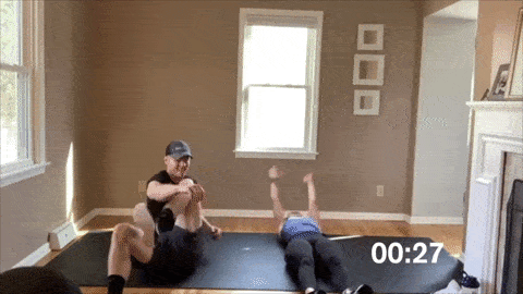 man and woman performing sprinter sit ups in a HIIT workout at home