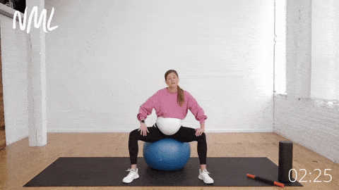 pregnant woman on stability ball performing adductor stretches